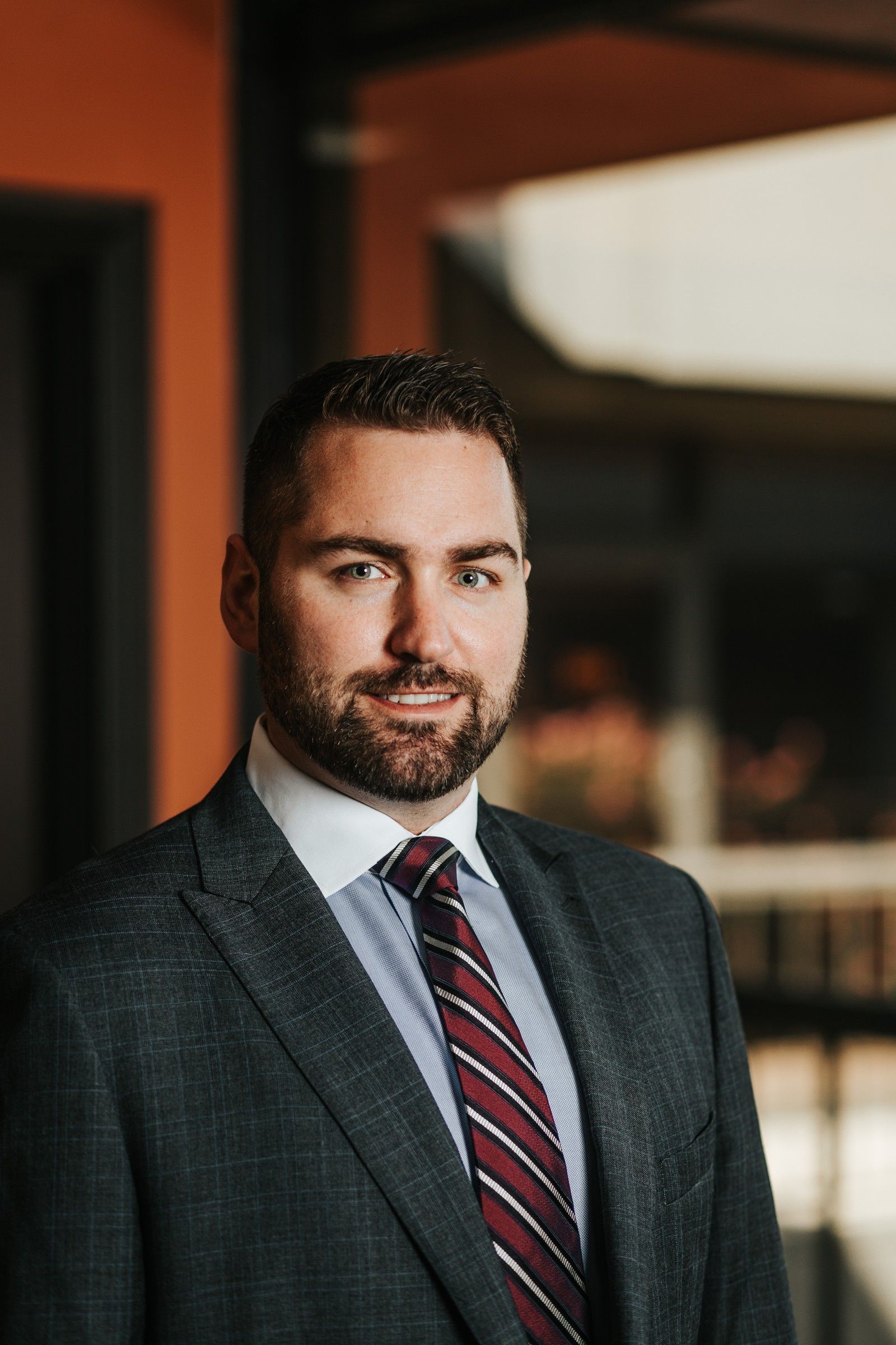 Brandon J. Grable, civil rights attorney in San Antonio, smiling in a gray suit and red striped tie