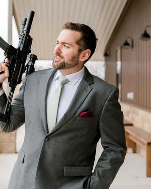 Brandon J. Grable, civil rights attorney in San Antonio, holding a rifle outdoors