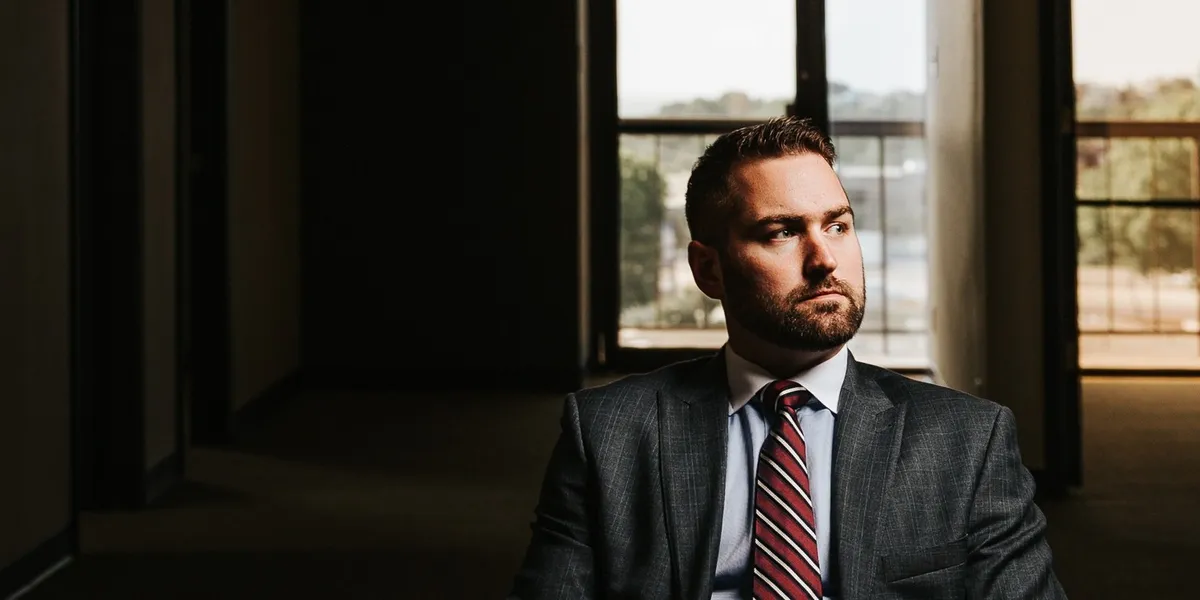 Brandon J. Grable, civil rights attorney in San Antonio, seated in a long office hallway